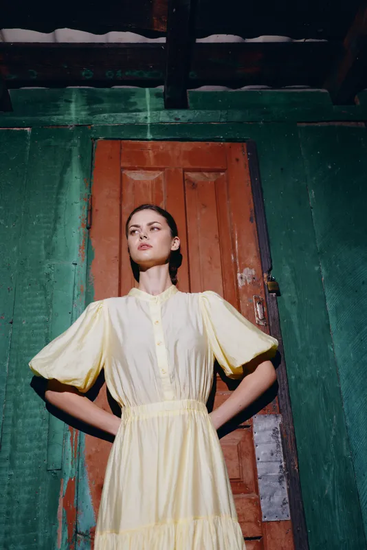 woman yellow dress portrait wooden door sunlight authenticity inclusivity fashion model