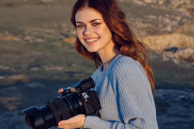 Женщина с фотоаппаратом в руках на открытом воздухе, в скалистых горах, хобби, путешествия