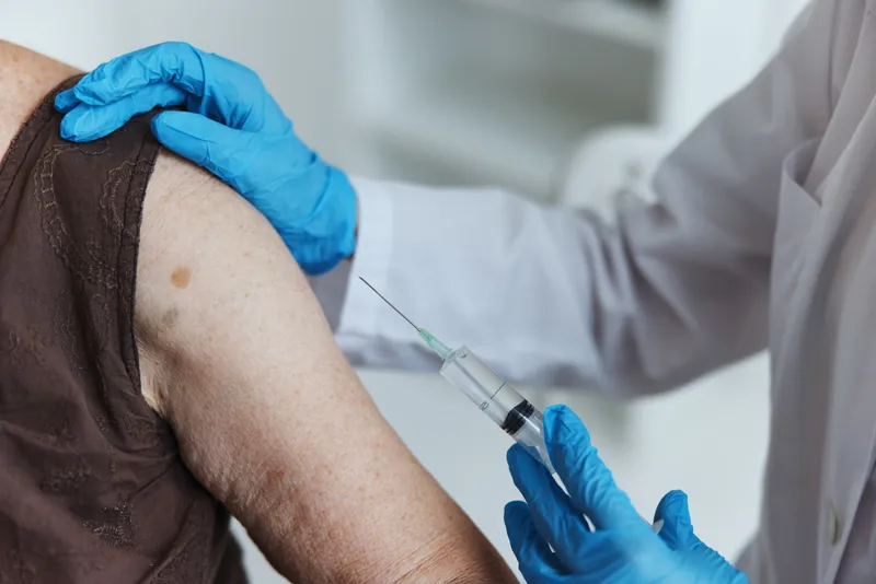 Врач со шприцем делает инъекцию в руку, вакцинный паспорт, крупный план
