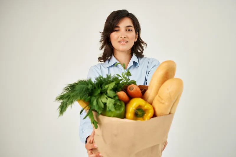 Улыбающаяся женщина в голубой рубашке с сумкой продуктов, овощи, здоровая пища, органические продукты