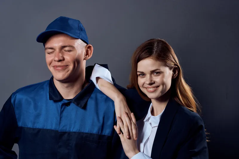 Рабочий мужчина и деловая женщина стоят рядом и беседуют