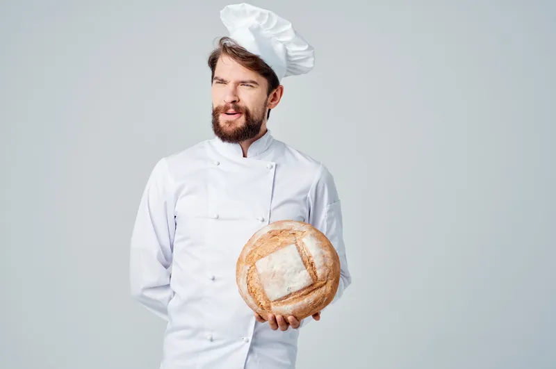Повар на кухне, работа с хлебобулочными изделиями на изолированном фоне
