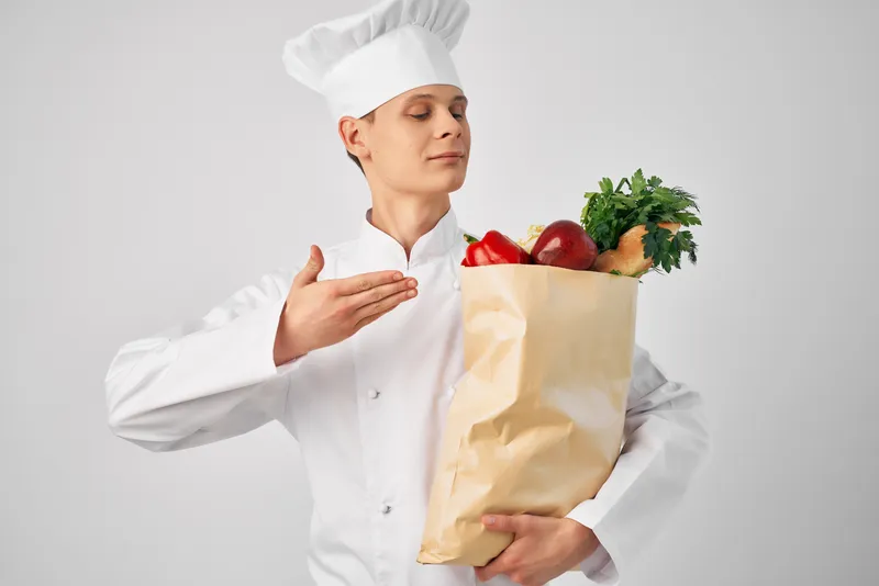 Мужчина с упаковкой продуктов для здорового питания работает на кухне ресторана