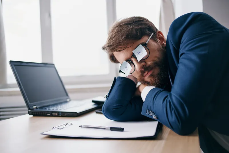 Менеджер работает за ноутбуком в офисе, испытывая эмоции, связанные с интернетом и официальной обстановкой