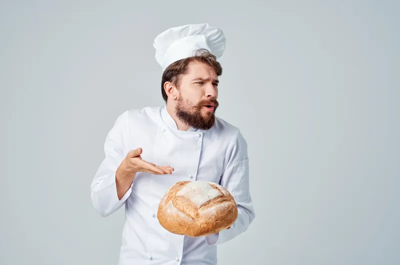 Пекарь на кухне, работа с хлебобулочными изделиями на изолированном фоне