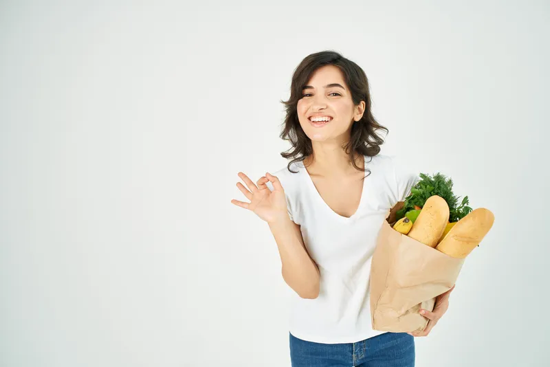 Женщина с пакетом продуктов и овощей