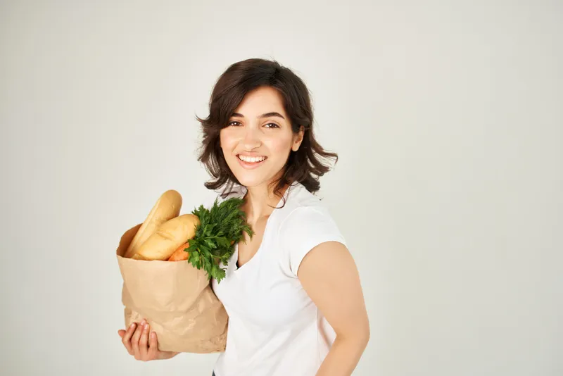 Брюнетка с пакетом продуктов, овощей, доставка