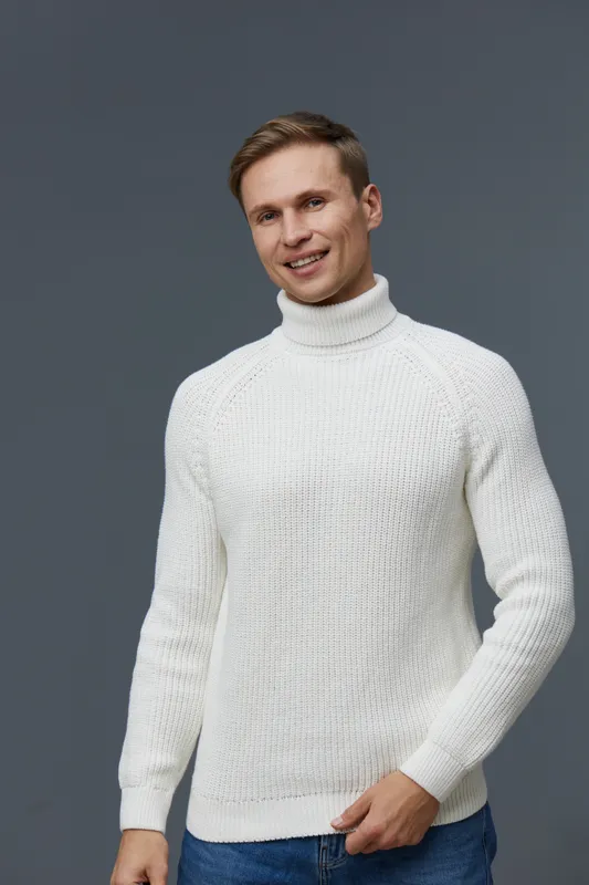 Confident young man wearing white turtleneck sweater smiling looking at camera studio portrait isolated on gray background casual fashion menswear concept