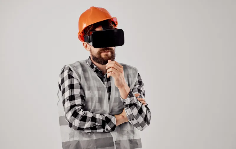 Инженер-строитель в 3D-очках виртуальной реальности и оранжевой каске на голове