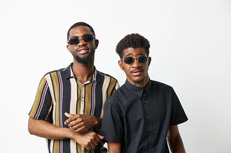 Stylish black men wearing sunglasses, showcasing confidence and friendship, perfect for representing modern urban culture and lifestyle.