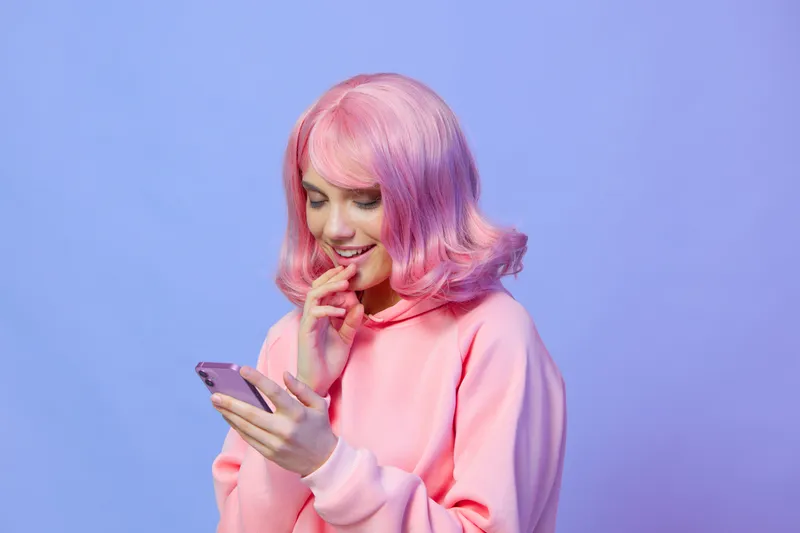 Женщина пользуется смартфоном, улыбается, демонстрируя технологии и стиль жизни