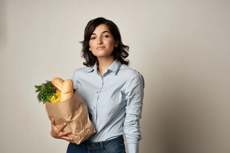 Женщина с упаковкой продуктов из супермаркета для здорового питания