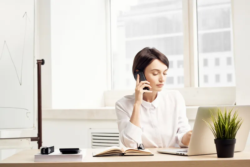 Женщина-менеджер в очках в офисе, излучающая уверенность в себе