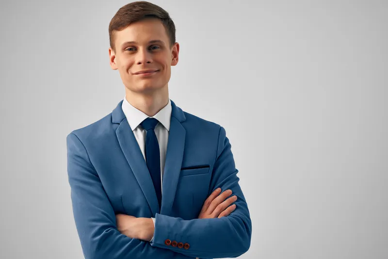 Деловой мужчина в костюме сложил руки перед собой, демонстрируя уверенность в себе и профессиональный настрой