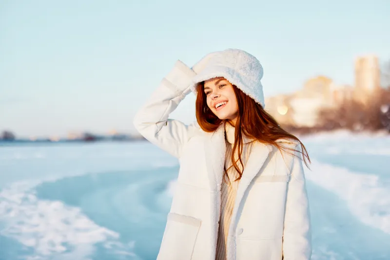 Женщина в зимней одежде гуляет по снегу в холодную погоду, отдыхая на природе