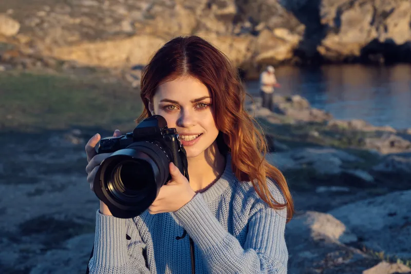 Симпатичная женщина-фотограф на природе в скалистых горах, приключение