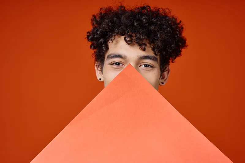 Женщина и мужчина с кудрявыми волосами держит в руках постер, студийная крупным планом съемка