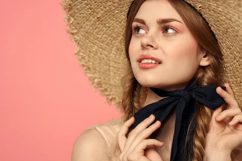 Романтичная девушка с косичками и в соломенной шляпе, улыбка, романтика, розовый фон, свободное пространство