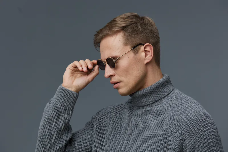 Profile portrait serious young caucasian man gray turtleneck sunglasses look side minimal dark background mental health gadgets concept