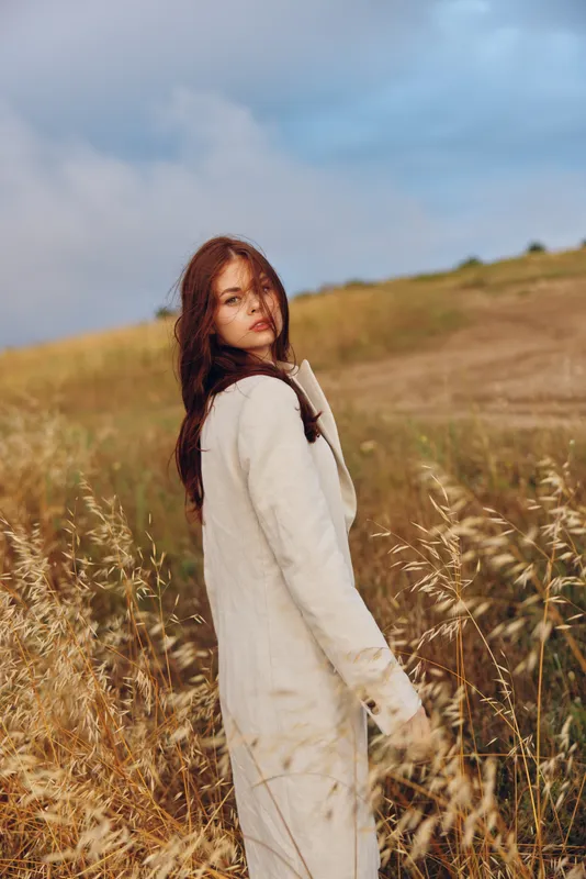 Женщина в пальто гуляет на улице в солнечный день
