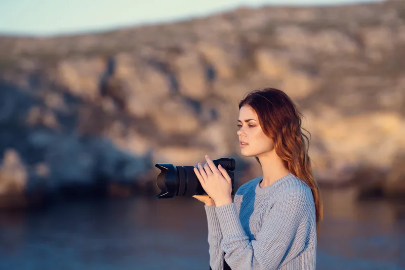 Женщина-туристка с фотоаппаратом на фоне скалистых гор, путешествие, профессионалы