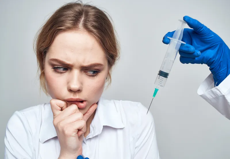 Женщина со шприцем, анестезия, инъекция ботокса, врач в синих перчатках