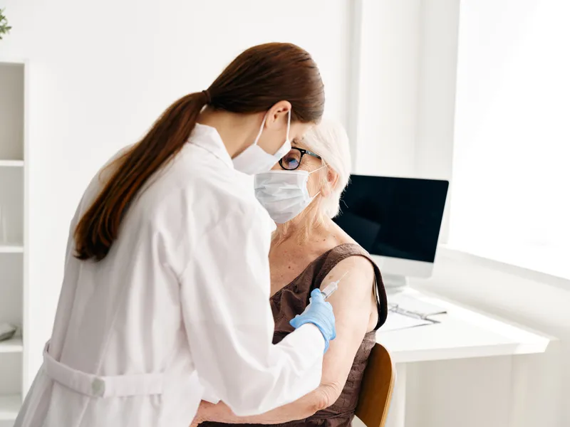 Врач и пациентка обсуждают вакцинацию от COVID-19 и паспорт здоровья
