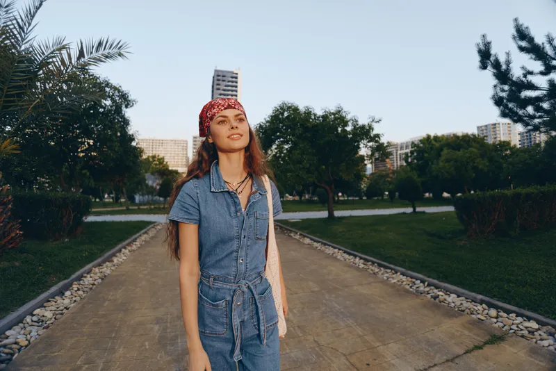 lifestyle woman in modern boho-western denim street style walking outdoors with film color effect, casual summer outfit, relaxed mood, natural background
