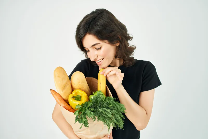 Женщина с пакетом продуктов из супермаркета