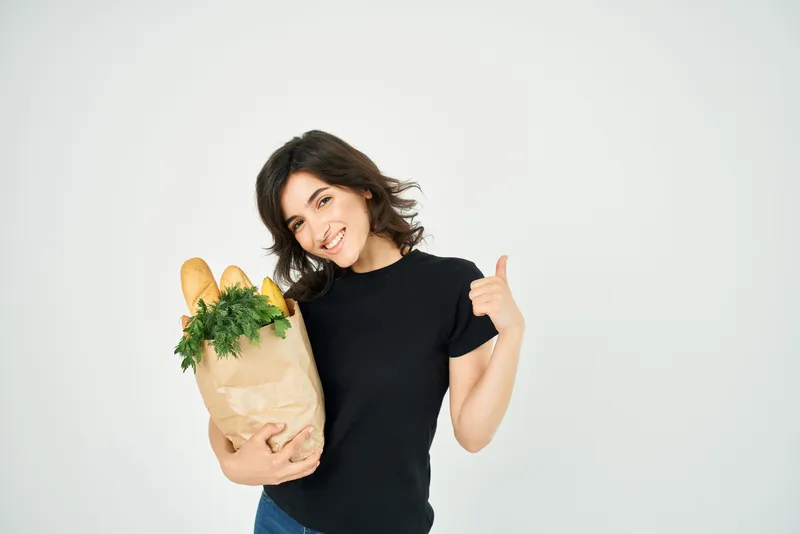 Женщина с пакетом продуктов из супермаркета