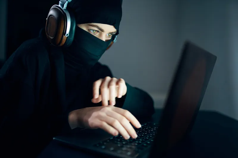 Женщина ночью сидит перед ноутбуком в наушниках, интернет-технологии