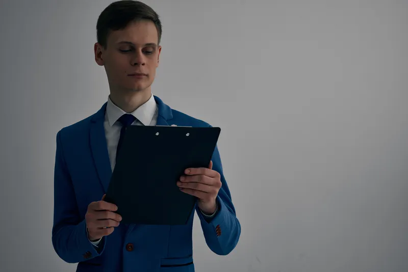 Менеджер в костюме с документами профессионально работает в офисе