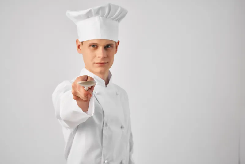 Шеф-повар с кухонной утварью в ресторане, профессиональная работа, приготовление еды