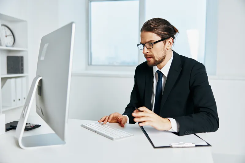 Офисный работник в костюме занимается офисной работой с телефоном
