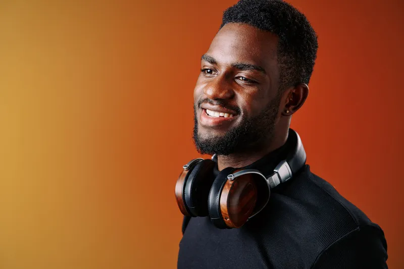 Smiling African man with headphones on colorful background showcasing joy, music, and modern lifestyle in vibrant tones, ideal for lifestyle and music related projects