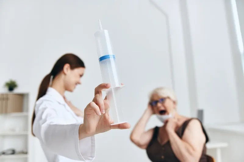 Медсестра делает укол пожилой женщине, вакцинация, вакцинный паспорт