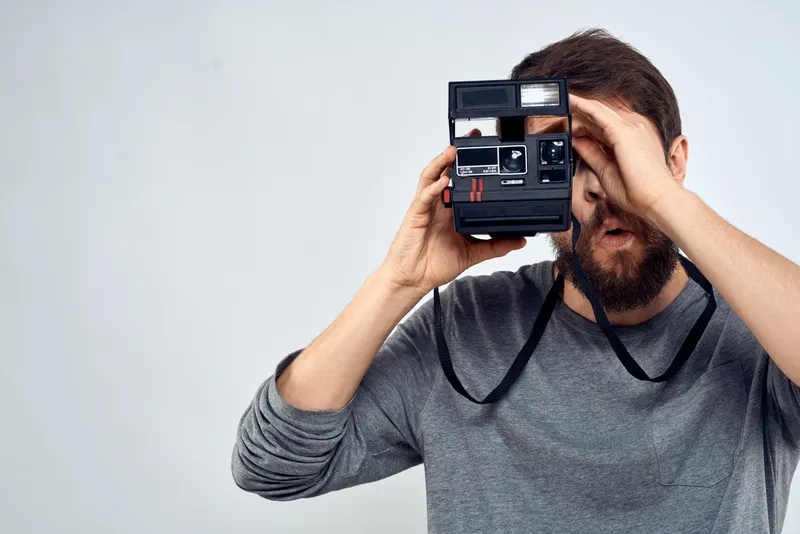 Фотограф-мужчина, профессиональная камера, работа, студия, технологии, современное искусство, светлый фон