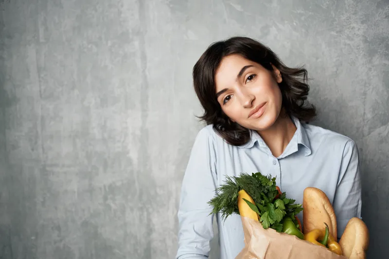Женщина с пакетом продуктов из супермаркета
