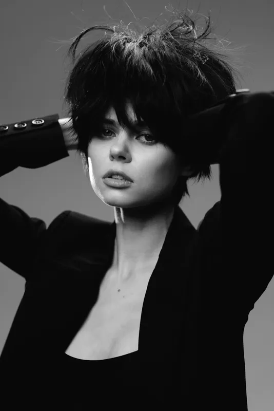 black and white portrait of a stylish woman with short dark hair posing confidently in a blazer