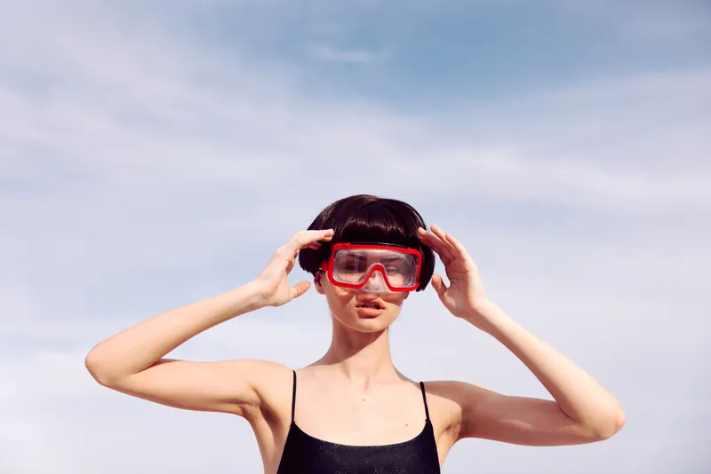 Тропическое блаженство: улыбающаяся женщина в красном купальнике для подводного плавания наслаждается отпуском на пляже