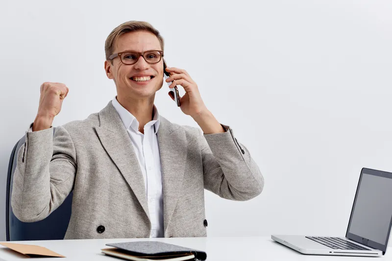 smiling man working remote freelancer excited talking phone modern casual suit digital nomad concept