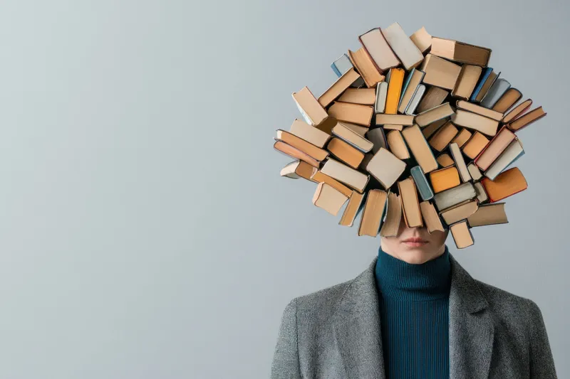 Концептуальный портрет модели с головой из книг, олицетворяющий креативность и интеллект