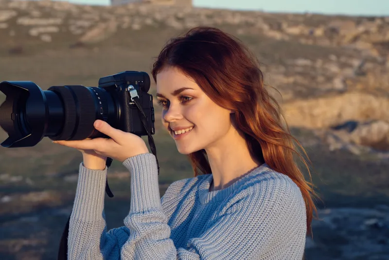 Женщина с фотоаппаратом в руках на открытом воздухе, в скалистых горах, хобби, путешествия