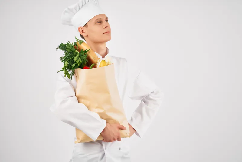 Мужчина в униформе повара с упаковкой продуктов, ресторанный кухонный сервис