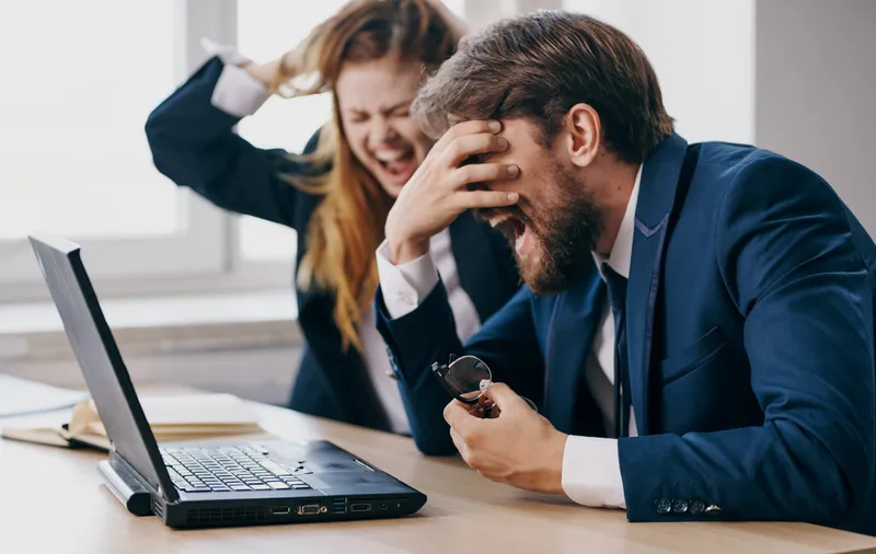 Мужчина и женщина работают за столом с ноутбуком, технологии, офис, эмоции, общение