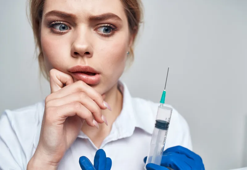 Женщина, шприц, анестезия, инъекция ботокса, врач в синих перчатках