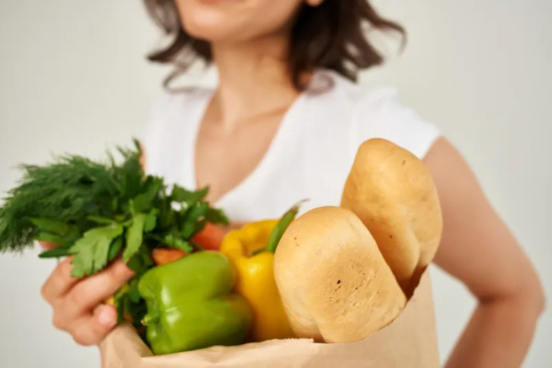Женщина с пакетом овощных продуктов, крупный план, кадрированный вид