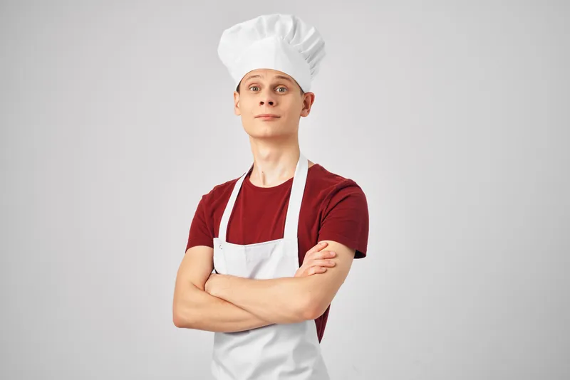 Мужчина в фартуке профессионально работает на кухне