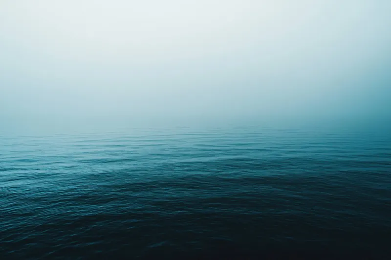 Спокойный морской пейзаж с безмятежными водами под туманным небом