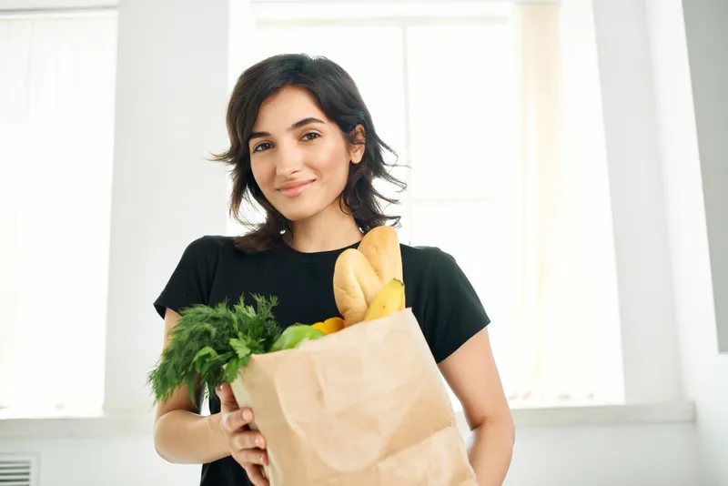 Привлекательная женщина с пакетом полезных продуктов — овощей